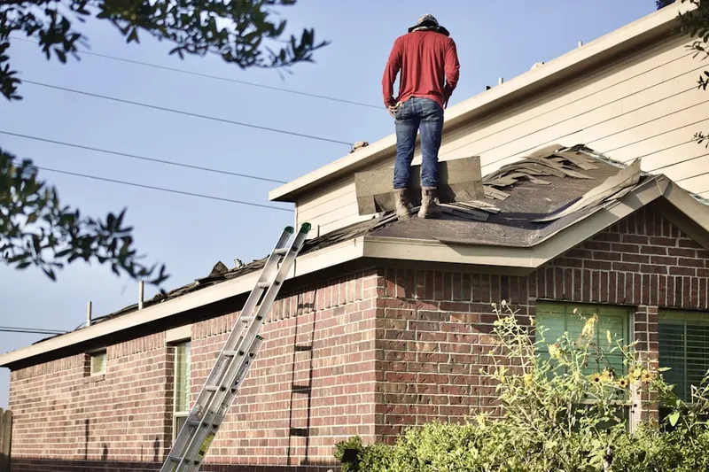 Professional roofer working on a residential roof in Land of Promise